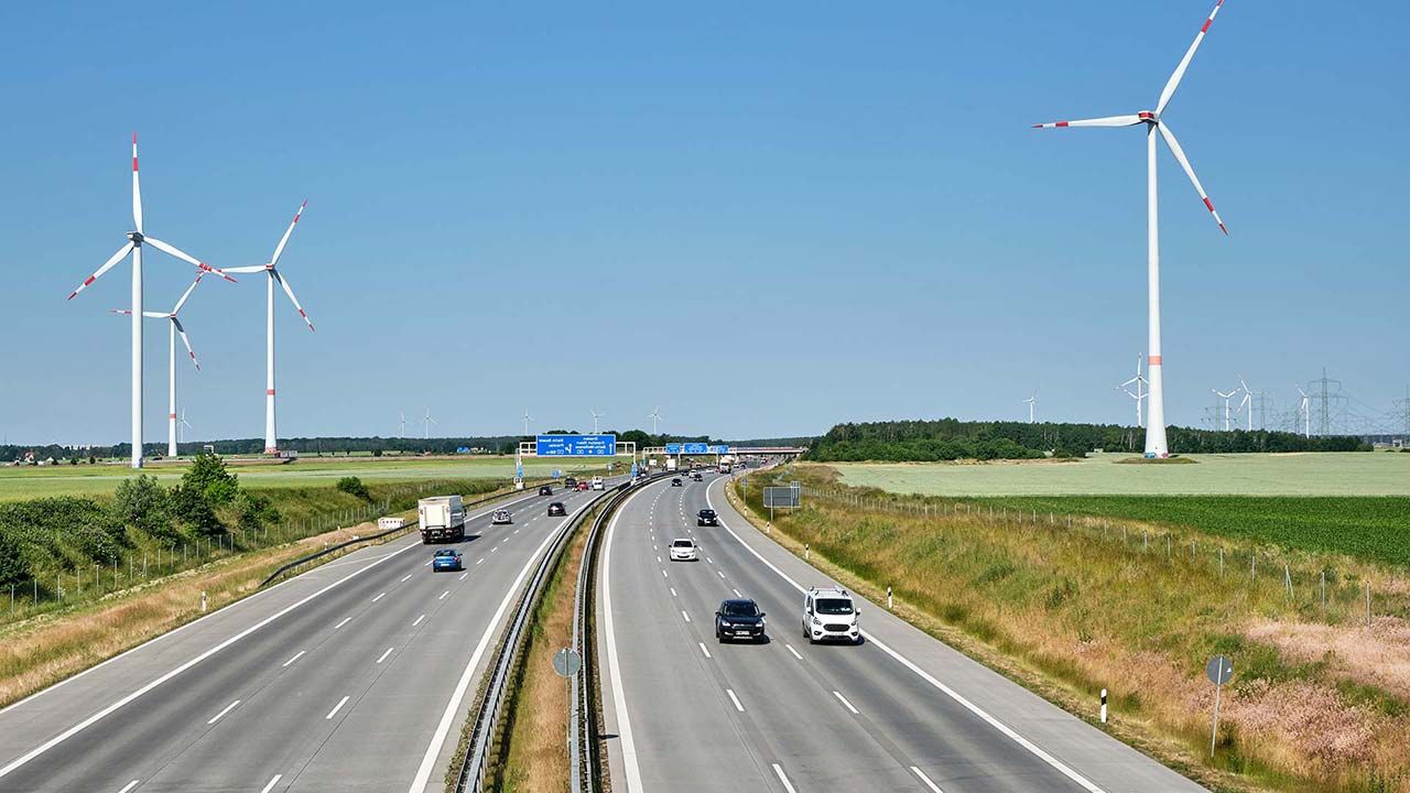 Foto einer britischen Autobahn mit Windrädern im Hintergrund.