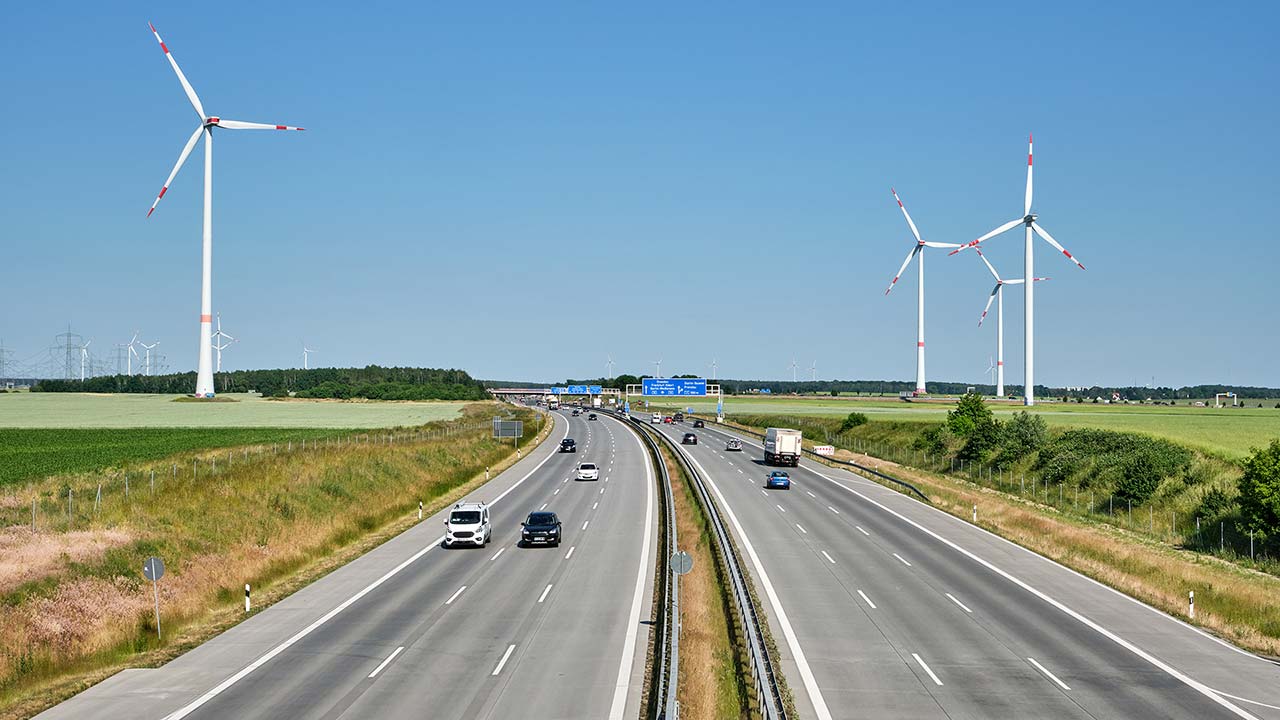Photo d'une autoroute france avec des éoliennes en arrière-plan.