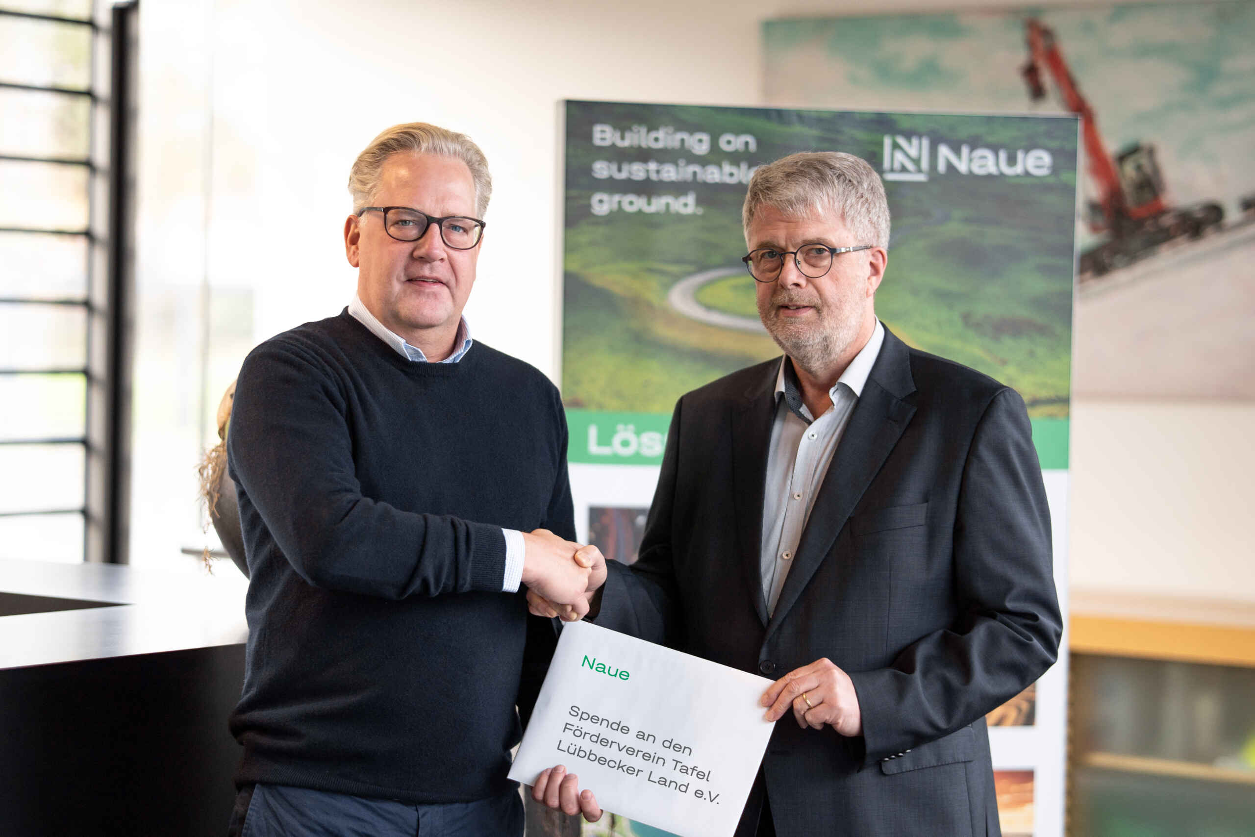Sebastian Naue presents a donation to Mr Obernolte from the Luebbecker Land food bank support association